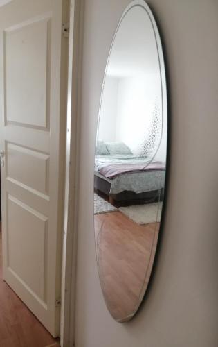 a mirror hanging on a wall next to a bedroom at Sosa's villa. (Free Coffee, BBQ & Garden Fruits) in Turku