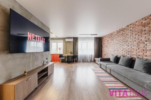 a living room with a couch and a brick wall at Двухкомнатные фирменные апартаменты Тиффани in Petropavlovsk