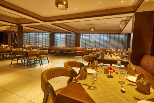 a restaurant with tables and chairs in a room at Hotel G-Square - Shirdi in Shirdi