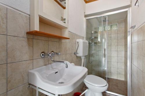 W łazience znajduje się umywalka, toaleta i prysznic. w obiekcie Robinson House Nicolina w Hvarze