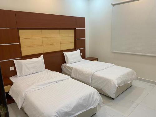 Hotat bani tamim的住宿－أباهي للوحدات السكنية الحوطة，配有白色床单的酒店客房内的两张床