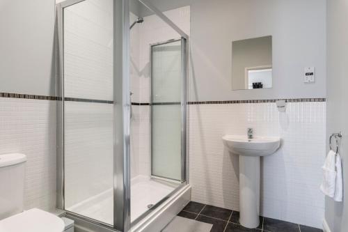uma casa de banho com um chuveiro, um WC e um lavatório. em Stunning 2BR, 2BA, Apartment - Super King Size Beds - Free Parking - 6 mins to LGW Airport em Crawley