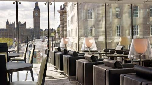 a row of tables and chairs with a view of big ben at Park Plaza Westminster Bridge London in London