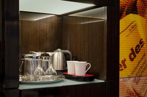 a shelf with cups and cups on it at Park Plaza London Westminster Bridge in London