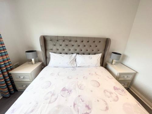 a bedroom with a large bed with two night stands at Paradise on earth in Garthamlock
