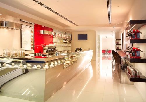 a bar in a restaurant with a counter and chairs at Park Plaza London Westminster Bridge in London