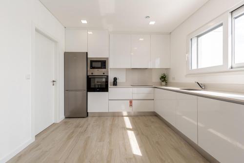 MariquiteiraにあるVilla Patricia with private swimming poolの白いキャビネットとステンレス製の電化製品を備えたキッチン