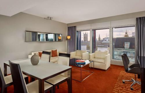 a living room with a table and chairs at Park Plaza London Westminster Bridge in London