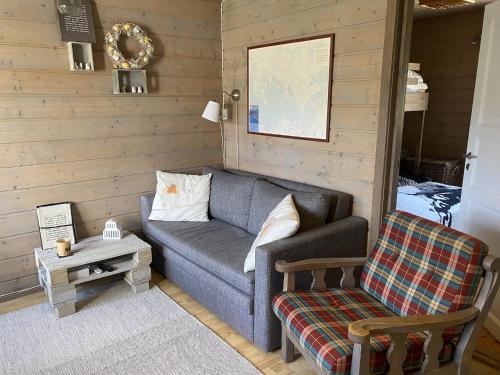 a living room with a couch and a chair at Osetunet, small and charming cabin at Ustaoset in Ustaoset
