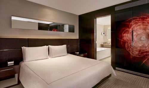a bedroom with a large white bed and a painting at Park Plaza London Westminster Bridge in London