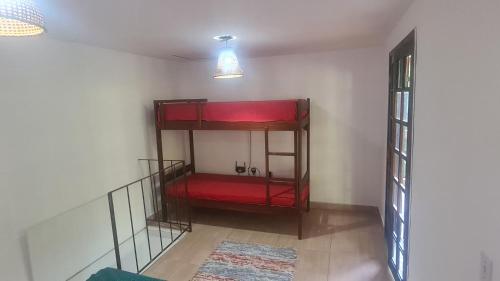a room with a red bunk bed in a room at Casa na praia do Felix na cidade de Ubatuba in Ubatuba
