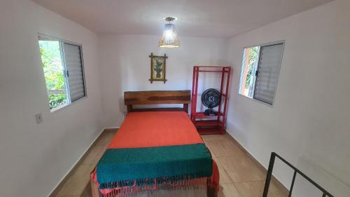 a bedroom with a bed in a room with windows at Casa na praia do Felix na cidade de Ubatuba in Ubatuba