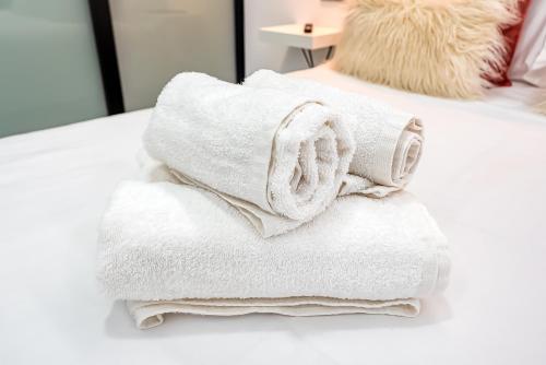 Una pila de toallas encima de una cama en Sun&Sea in Playa las Canteras, en Las Palmas de Gran Canaria