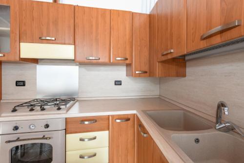 a kitchen with wooden cabinets and a sink at Appartamento in Piazza in Moniga