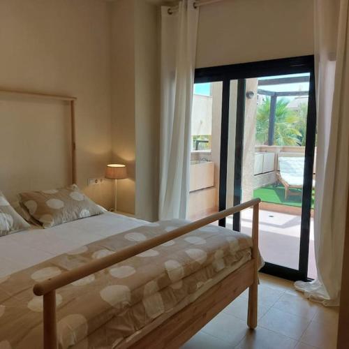 1 dormitorio con cama y vistas a un patio en Un Oasis en Hacienda del Álamo, en Murcia