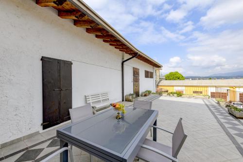 a patio with a table and chairs on a balcony at Appartamento in Piazza in Moniga