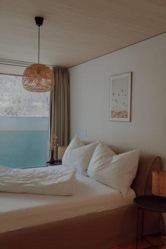 a bedroom with a bed with white pillows and a lamp at Stunning and Modern House On The Lake in Quarten