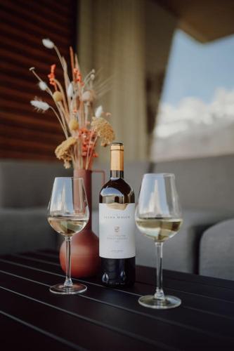 a bottle of wine and two wine glasses on a table at Stunning and Modern House On The Lake in Quarten