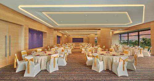 a banquet hall with white tables and chairs at Hyatt Regency Chennai in Chennai