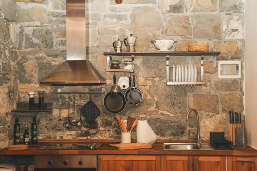 a kitchen with a sink and a stone wall at Holiday Home GaMaJaMa in Dobravlje