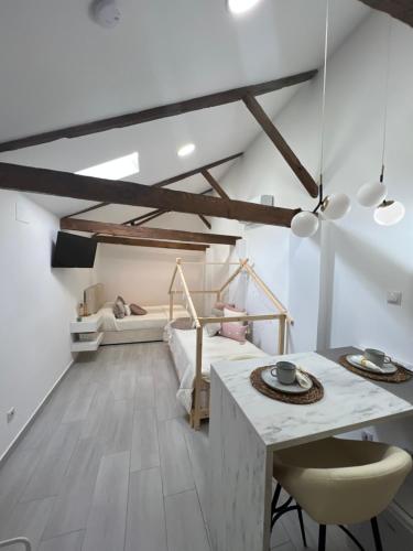 a bedroom with a bed and a table and chairs at Suites Chic Star in Herencia