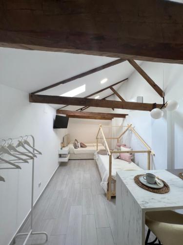 1 dormitorio en el ático con 1 cama y 1 mesa en Suites Chic Star, en Herencia