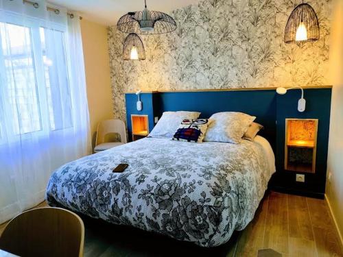a bedroom with a large bed with a blue headboard at La Waide in Amiens