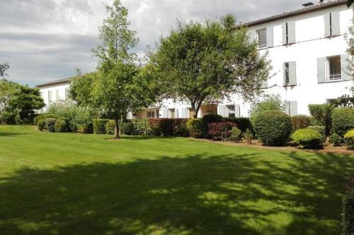 a large yard with trees and a building at L'Eucalyptus in Marans