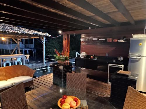 uma cozinha e sala de estar com uma mesa com uma taça de fruta em ILHA Da FANTASIA, SUITE BANGALÔ em Belém