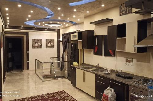 uma grande cozinha com um tecto com uma espiral em Luxury Duplex 450m 4BR For Familias no Cairo