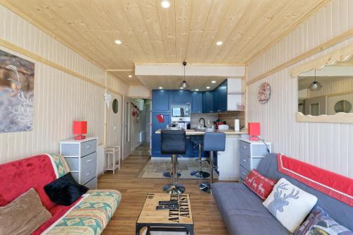 a living room with a couch and a kitchen at Le Panorama Orcières - Appt vue montagne in Orcières