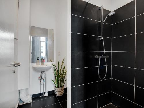 ein Bad mit einer Dusche und einem Waschbecken in der Unterkunft Sanders City - Spacious studio apartment in Kopenhagen