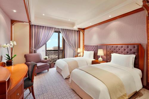 a hotel room with two beds and a desk at The Ritz-Carlton Jeddah in Jeddah