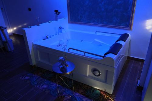 ein großes Badezimmer mit einer Badewanne mit blauer Beleuchtung in der Unterkunft SUITE LA VILLA in Statte