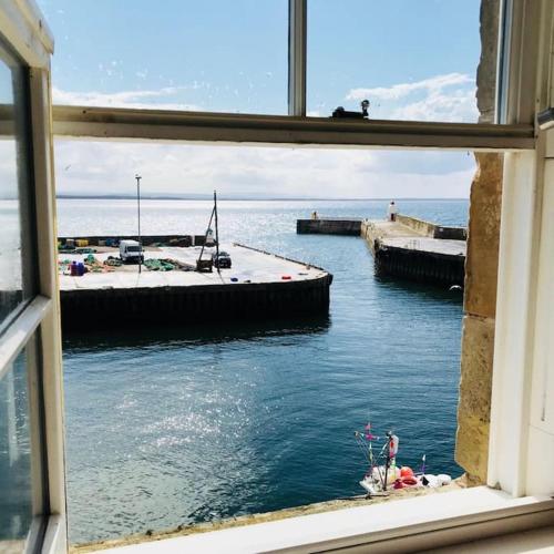 a view of the water from a window at Harbour Side, Luxury, Twin Level Loft in Burghead