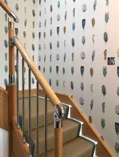 a staircase with a wall with a wallpaper with elephants at Harbour Side, Luxury, Twin Level Loft in Burghead