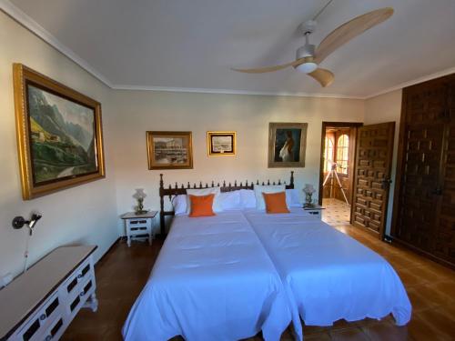 ein Schlafzimmer mit einem großen blauen Bett mit orangefarbenen Kissen in der Unterkunft Casa del Pintor Antonio Mesa in Mombeltrán