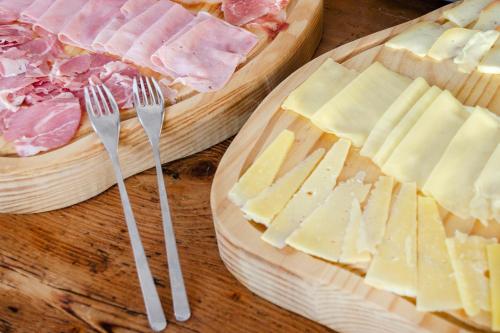two plates of cheese and forks on a table at Cheese & Wine Lapa in Lisbon