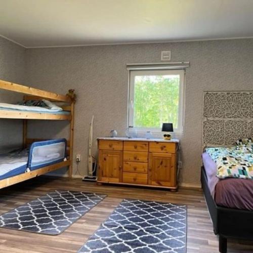 HamraにあるFamilienfreundliche Farm Stugaのベッドルーム1室(二段ベッド2台、ドレッサー、窓付)が備わります。