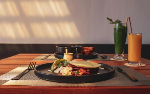 a table with a plate of food on a table at LalaGalu - Beachfront EcoCabins in Diani Beach