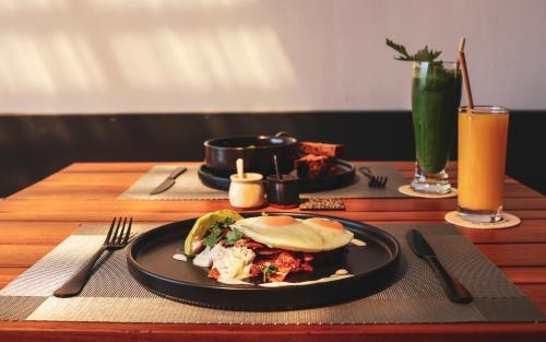 a table with a plate of food on a table at LalaGalu - Beachfront EcoCabins in Diani Beach
