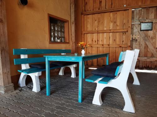 uma mesa azul com duas cadeiras brancas e um banco azul em Ferienhaus Bayerlipp em Scheßlitz