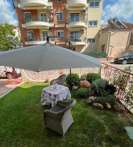 a table and chairs under an umbrella in a yard at Smile studio in Drama