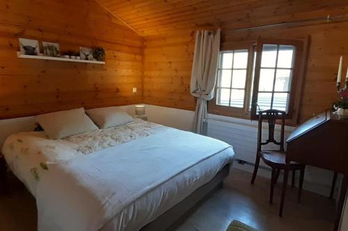 sypialnia z łóżkiem i biurkiem w pokoju w obiekcie Chalet d'Ayral avec jardin privatif w mieście Leysin