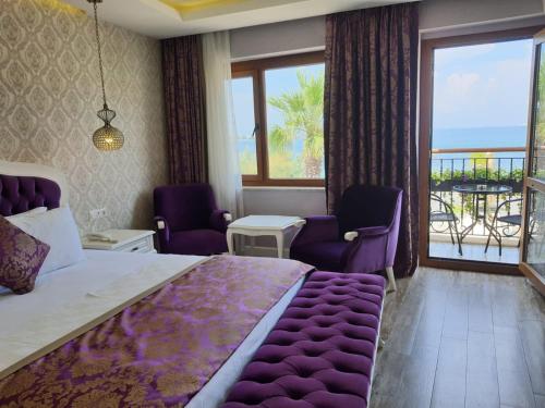 YenifoçaにあるFocamor Otelのベッドルーム(大きな紫色のベッド1台、バルコニー付)