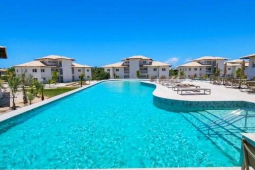a pool at a resort with blue water at Villa PF Village - Praia do Lord in Praia do Forte