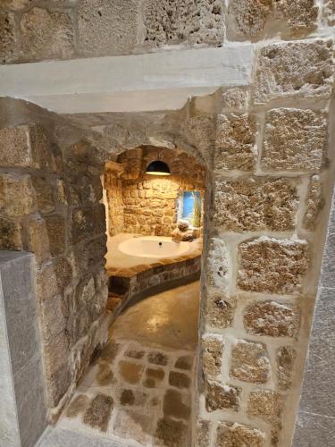 a stone bathroom with a tub in a stone wall at Akotika boutique in ‘Akko
