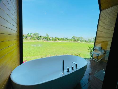 uma banheira na casa de banho com uma grande janela em Whitehouse resort 