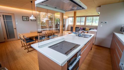 uma cozinha com um lavatório e uma sala de jantar em Serenity Chalet, walk to the lifts Happoone Ski Resort em Hakuba
