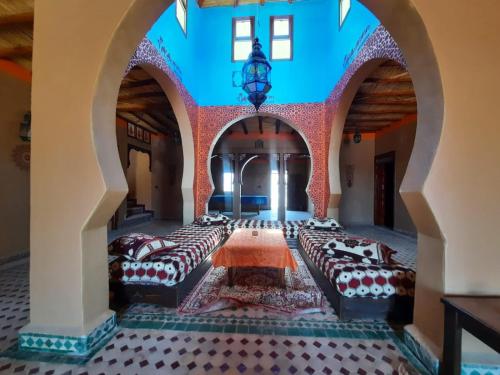 a room filled with lots of beds in a building at Riad family in Merzouga